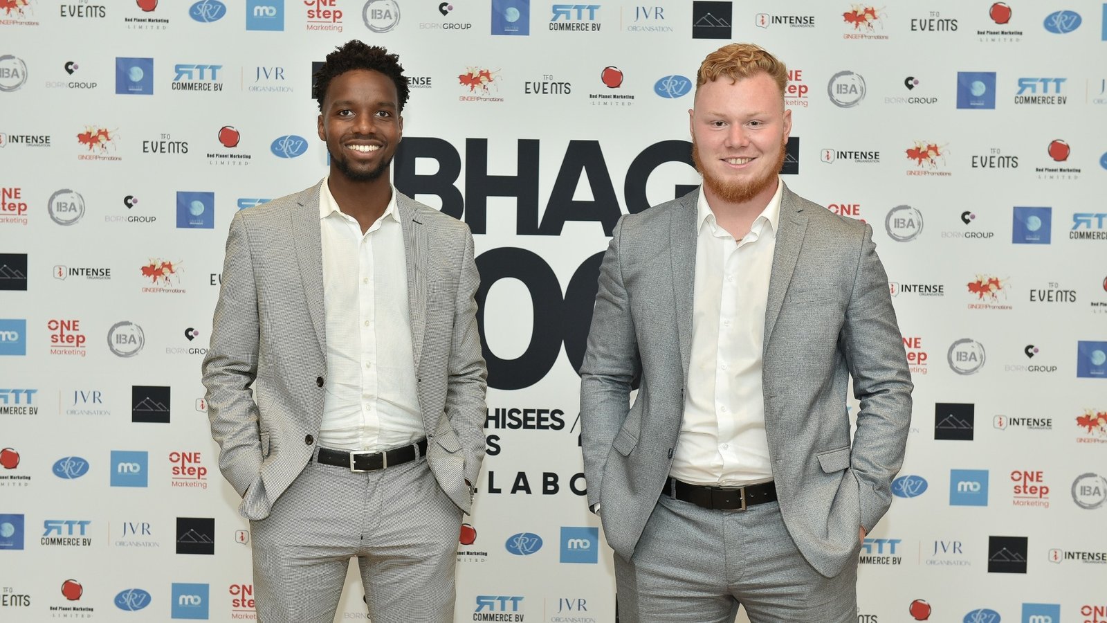 Two team members at event backdrop
